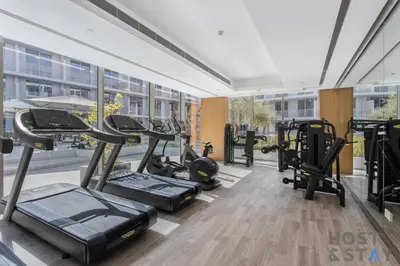 a gym with treadmills and ellipticals in a building at Charming Studio in Luma 22, Jumeirah Village Circle in Dubai