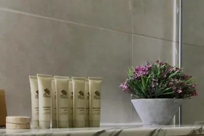 a group of three products on a table next to a vase of flowers at Burj Khalifa Downtown Views - Highest Infinity Pool in Downtown in Dubai