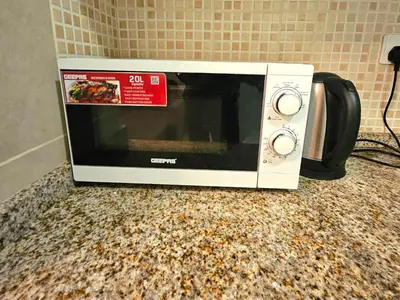 a microwave sitting on top of a counter at Stunning Apartment - High Floor - Canal View - Goldcrest Exectutive Tower in Dubai