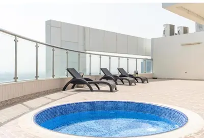 a balcony with chairs and a pool on a building at Stunning Apartment - High Floor - Canal View - Goldcrest Exectutive Tower in Dubai