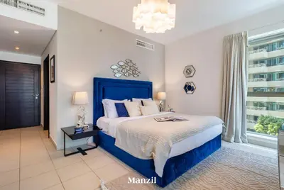 a bedroom with a blue bed and a window at Stylish 2BR with Burj Khalifa View near Dubai Mall in Dubai