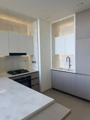 a kitchen with white cabinets and a sink and a stove at Ramadan Staycation offers Miracle Home Haven in Dubai