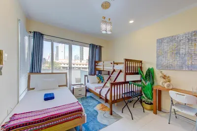 a bedroom with two beds and a desk at Ramadan Staycation offers Miracle Home Haven in Dubai