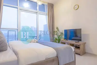 a bedroom with a bed and a large window at Bloomfields Stu In Carson in Dubai