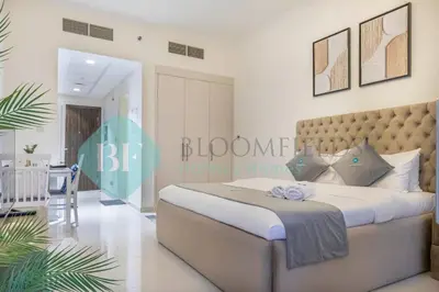 a bedroom with a large bed and a dining room at Bloomfields Stu In Carson in Dubai