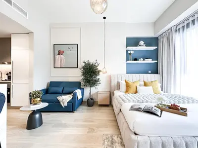 a living room with a couch and a blue sofa at Meydan Living - Unwavering Excellence in Dubai