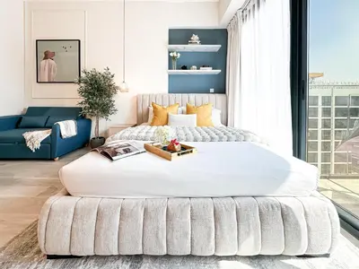 a large bed in a bedroom with a blue couch at Meydan Living - Unwavering Excellence in Dubai
