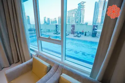 a window with a view of a swimming pool at Alashrafia Saray- Classy 1BDR apartment in Canal Views in Dubai