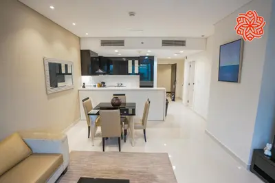 a dining room and kitchen with a table and chairs at Alashrafia Saray- Classy 1BDR apartment in Canal Views in Dubai