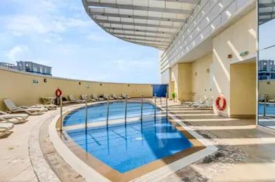 a swimming pool on the roof of a building at Waves - Charming Studio with Lake Views Close to Metro in Dubai