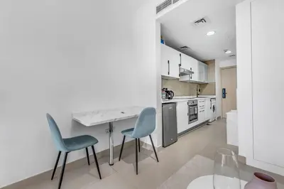 a kitchen with two chairs and a table in it at Waves - Charming Studio with Lake Views Close to Metro in Dubai