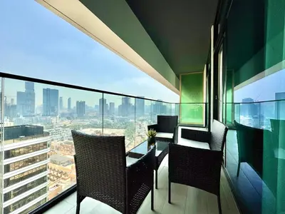 a balcony with a table and chairs and a view at Luxe 2br With Fast Wi-fi Parking, Gym And Pool! in Dubai