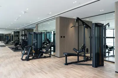 a gym with treadmills and ellipticals in a building at Luxe 2br With Fast Wi-fi Parking, Gym And Pool! in Dubai