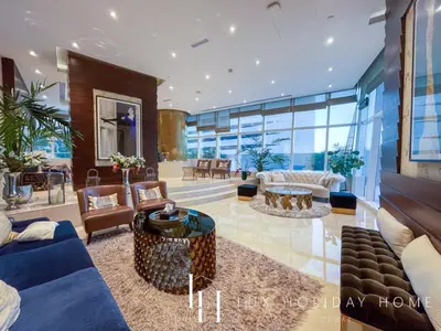 a living room with couches and tables and windows at LUX Lavish Suite with Full Marina View 4 in Dubai