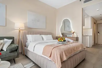 a bedroom with a large bed with a bowl of fruit on top at luxury Santorini studio style in Dubai