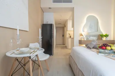 a room with a bed and a table with a bowl of fruit at luxury Santorini studio style in Dubai