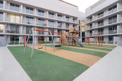 a playground in front of a apartment building at luxury Santorini studio style in Dubai