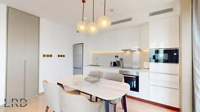 a white kitchen with a white table and chairs at Classy & Cozy 2BR Harbour Point in Dubai