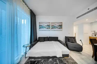a bedroom with a large bed and a couch at Lovely 1BD apartment in La Vie Dubai in Dubai