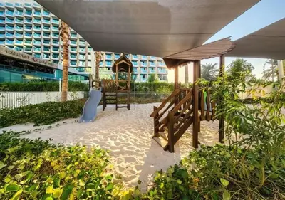 a patio with a wooden table and a building at Lovely 1BD apartment in La Vie Dubai in Dubai