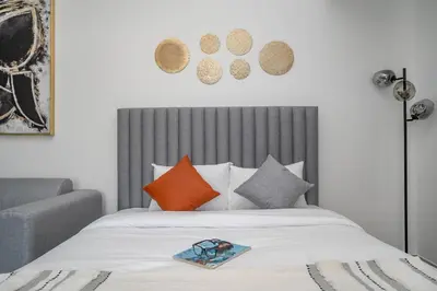 a bedroom with a bed with orange and grey pillows at Spacious and Modern Studio -Great Facilities in Dubai