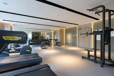 a gym with treadmills and machines in a room at Spacious and Modern Studio -Great Facilities in Dubai