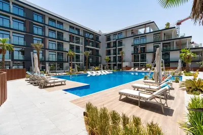 a hotel with a swimming pool and lounge chairs at Spacious and Modern Studio -Great Facilities in Dubai