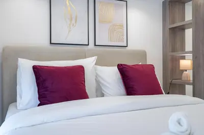 a bedroom with a bed with purple and white pillows at Trendy Loft Studio in Oxford Terrace JVC in Dubai