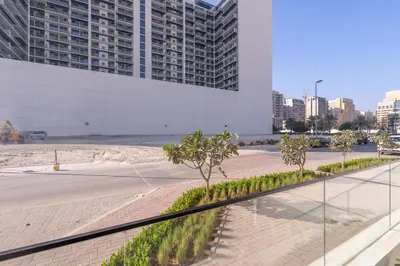 a walkway with trees in front of a building at Trendy Loft Studio in Oxford Terrace JVC in Dubai