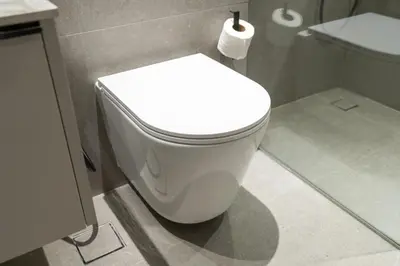 a white toilet in a bathroom with a roll of toilet paper at Trendy Loft Studio in Oxford Terrace JVC in Dubai