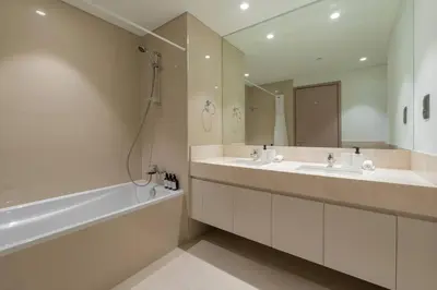 a bathroom with two sinks and a tub and a mirror at Dubai Opera - Luxury 2 Bedroom Apartment - Near Burj Khalifa in Dubai