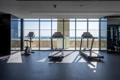 a gym with several treadmills and a large window at 2BR Luxury Retreat - Stunning Canal and Sea View in Dubai