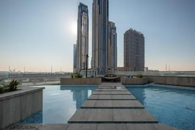 a swimming pool in a city with tall buildings at 2BR Luxury Retreat - Stunning Canal and Sea View in Dubai