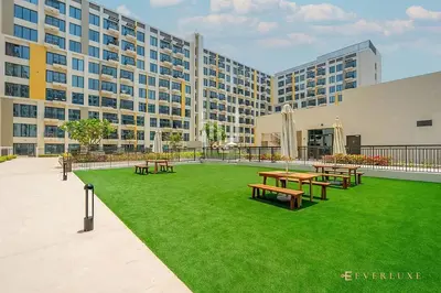 a courtyard with picnic tables in front of a building at Chic Liva 1br Family-friendly Great Amenities in Nadd Shubayḩ