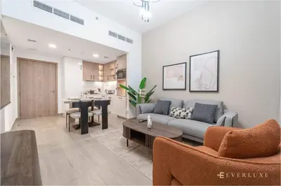 a living room with a couch and a table at Chic Liva 1br Family-friendly Great Amenities in Nadd Shubayḩ