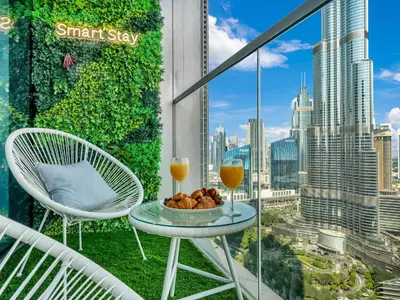 a balcony with a table and two glasses of orange juice at SmartStay at Grande Signature - Burj Khalifa View - 5 min Dubai Mall - Downtown Dubai - Brand New Luxury Apartments in Dubai