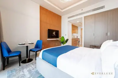 a hotel room with a bed and a table and chairs at Everluxe Modern Pool View Studio In Al Jaddaf in Dubai