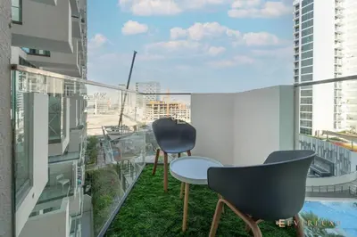 a balcony with chairs and a view of a city at Everluxe Modern Pool View Studio In Al Jaddaf in Dubai
