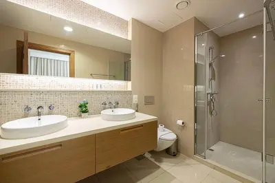 a bathroom with two sinks and a shower and a toilet at Lux Unit with Burj & Fountain View I Walk Dubai Mall in Dubai