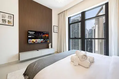 a bedroom with a large white bed and a large window at Lux Unit with Burj & Fountain View I Walk Dubai Mall in Dubai