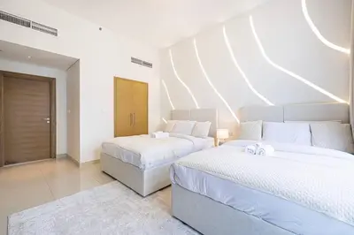 two beds in a large room with white walls at Lux Unit with Burj & Fountain View I Walk Dubai Mall in Dubai