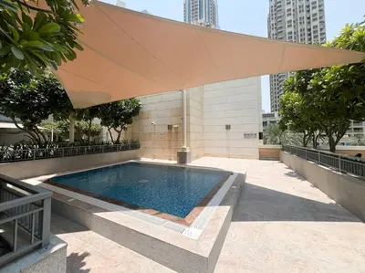 a swimming pool with a large tan umbrella at Lux Unit with Burj & Fountain View I Walk Dubai Mall in Dubai