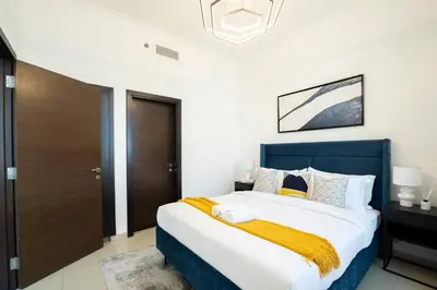 a bedroom with a large bed with a blue headboard at Stunning 1BR with Palm Jumeriah View in Marina in Dubai
