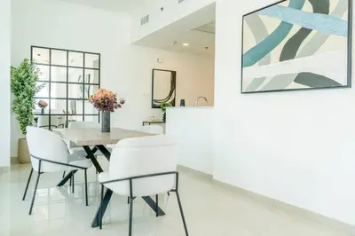 a dining room with a table and white chairs at Stunning 1BR with Palm Jumeriah View in Marina in Dubai