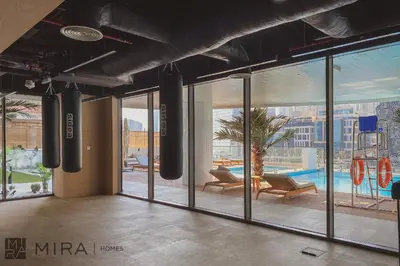 a large room with large glass windows and a pool at Mira Holiday Homes - Lovely new 1 bedroom in Downtown in Dubai