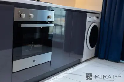 a microwave and a washing machine in a kitchen at Mira Holiday Homes - Lovely new 1 bedroom in Downtown in Dubai