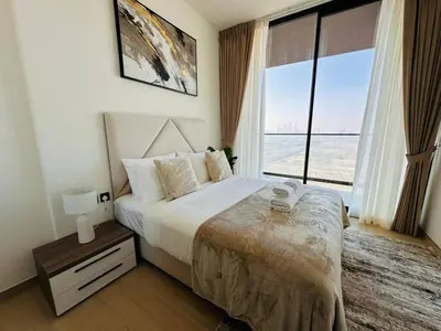 a bedroom with a bed and a large window at Furnished 1br In Jvc Pool Access Free Parking in Dubai