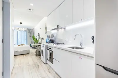 a white kitchen with white cabinets and a sink at Exquisite Modern Home Minutes from Downtown Dubai in Dubai