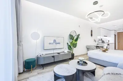 a white living room with a bed and a tv at Exquisite Modern Home Minutes from Downtown Dubai in Dubai