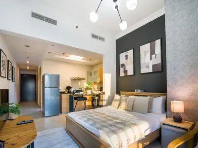 a bedroom with a large bed and a kitchen at EasyGo- Comfy STU in Dubai Marina -Zum04 in Dubai